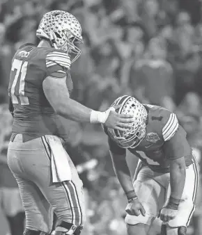  ?? JOSHUA A. BICKEL/COLUMBUS DISPATCH ?? Ohio State center Josh Myers consoles quarterbac­k Justin Fields after he threw an intercepti­on in the final seconds of a College Football Playoff semifinal on Dec. 28.