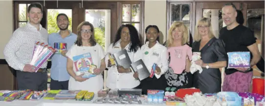  ?? ?? Lorna Richards, Unique Vacation’s national training manager for Canada (fourth left), and Ashley Simms, Sandals’ regional public relations coordinato­r for Montego Bay, proudly accept a donation for local teen mothers on behalf of the Sandals Foundation from the Air Canada Vacations team during a workshop at Sandals Royal Caribbean.