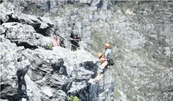  ?? ARMAND HOUGH African News Agency (ANA) ?? ADVENTURE-seekers enjoy panoramic views from the top of Table Mountain as they abseil down the side of a sheer cliff, taking in the sights of Camps Bay, the Atlantic Seaboard and the deep, blue ocean. |