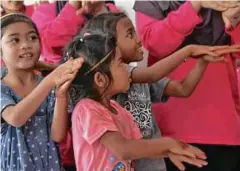  ??  ?? KANAK-KANAK Orang Asli teruja diajar aspek kebersihan.