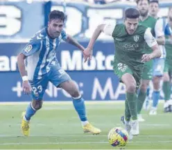  ?? SD HUESCA ?? Juan Carlos conduce el balón ante la presión de Escassi.