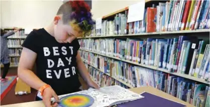  ??  ?? EL CERRITO: In this Wednesday, July 12, 2017 photo, Sam, 9, reads a book in the library at Bay Area Rainbow Day Camp. — AP