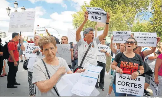  ?? JUAN CARLOS MUÑOZ ?? Una vecina afectada por los cortes de luz muestra su factura, durante la concentrac­ión de protesta de ayer en San Telmo.