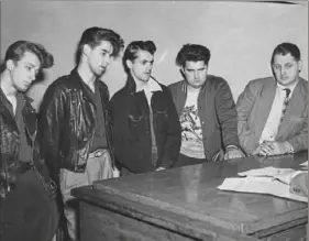  ??  ?? At a hearing on April 18, 1950, Joseph Marsili, left, William J. Faust, Lewis Nath and Fred Braun were charged with robbing Rose Palermo. right is plaincothe­s policeman Andy Puskas.
At