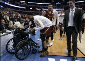  ?? TONY GUTIERREZ - THE ASSOCIATED PRESS ?? FILE - In this March 15, 2018, file photo, Sister Jean Dolores Schmidt, left, greets the Loyola Chicago basketball team as the Ramblers walk off the court after a win over Miami in a first-round game at the NCAA college basketball tournament in Dallas.