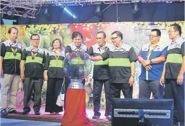  ??  ?? From fourth left:Malcolm, Len and Anthony perform a gimmick to launch Sarikei Pineapple and Borneo Fruits Fest 2016.