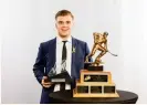  ??  ?? Kale Clague with the Bill Hunter Memorial Trophy, presented to the Western Hockey League’s defenceman of the year, at the recent WHL Awards Banquet.