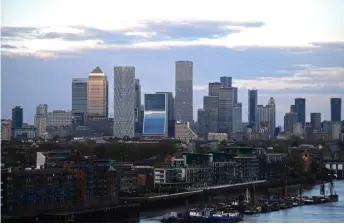  ??  ?? The secondary central business district of Canary Wharf is pictured as the sun sets in London. As Covid-19 wreaks severe economic damage, some British employers stand accused of taking a highly controvers­ial measure to stay afloat: fire and rehire.