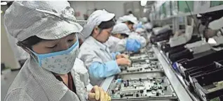  ?? GETTY IMAGES PHOTO ?? Workers assemble electronic devices at a Foxconn Technology Group factory in Shenzen, China.