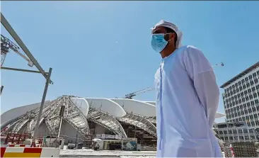  ??  ?? an emirati man stands outside the dubai expo 2020 site. organisers grappling with the complexiti­es of rescheduli­ng the event are intent on delivering the main buildings of the expo by the original start date.