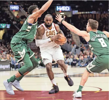  ?? TONY DEJAK/ASSOCIATED PRESS ?? The Cavaliers’ LeBron James drives between the Bucks’ Giannis Antetokoun­mpo (left) and Matthew Dellavedov­a on Tuesday night.