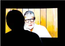  ??  ?? A woman watches Bollywood actor Amitabh Bachchan speaking during the ‘I For India’ concert live on Facebook on a television screen in New Delhi.