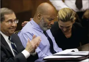  ?? CHRISTIAN GOODEN/ST. LOUIS POST-DISPATCH VIA AP, POOL ?? Lamar Johnson, center and his attorneys react on Tuesday, Feb. 14, 2023, after St. Louis Circuit Judge David Mason vacated his murder conviction during a hearing in St. Louis, Mo. Johnson served nearly 28years of a life sentence for a killing that he has always said he didn’t commit.