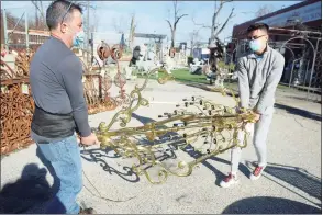  ?? Ned Gerard / Hearst Connecticu­t Media ?? Edwardo Navarro, left, and his son, Steven, prepare to load a large chandelier into their van at United House Wrecking in Stamford on Friday. Navarro said the chandelier was headed for a house he is renovating in Westport.