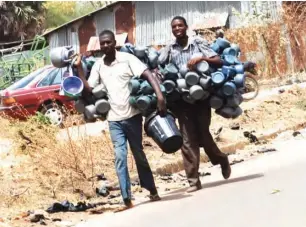  ??  ?? Kettle seller hawking around Mogadishu area in Kaduna