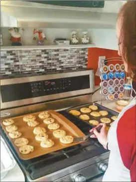  ??  ?? Emilee Atkins bakes batch of made from scratch cookies in her Polk County home.