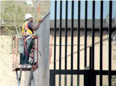  ?? LAURA BARTON/WELLAND TRIBUNE ?? A constructi­on worker inspects the outside of the new provincial offences courthouse on East Main Street in Welland, which is set to open in October.