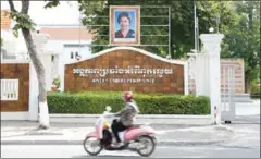  ?? PHA LINA ?? A motorbike passes in front of the Anti-Corruption Unit headquarte­rs in Phnom Penh. The ACU yesterday summonsed three high-ranking Council for Developmen­t of Cambodia officials for questionin­g.