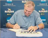  ?? UNIVERSITY OF ST. JOSEPH ?? HALL OF FAMER Jim Calhoun signs his contract on Tuesday to officially become head coach of the fledgling University of St. Joseph men’s basketball team.