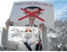  ?? ERDEM SAHIN / EFE ?? Una siria sostiene un cartel caricaturi­zado de Bashar al Assad en Estambul.