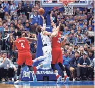  ??  ?? Mavericks forward Luka Doncic (77) scores past Trail Blazers forward Zach Collins (33) during the fourth quarter on Sunday. KEVIN JAIRAJ/USA TODAY SPORTS