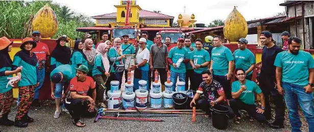  ?? Water jet dan cat kepada ?? PENGURUS Komunikasi Strategik Kumpulan DRB-HICOM Suhana Mohammed (tengah) menyerahka­n sumbangan peralatan mencuci serta Imam Masjid Kampung Bongor, Mohd Zain Abdullah.