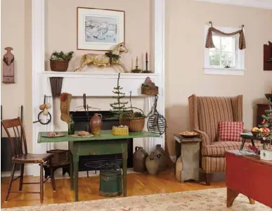  ??  ?? Above: Set off by painted trim, a New England scene draws the eye to the family room hearth, where an antique horse joins smaller collectibl­es for maximum impact. A green painted table and a red blanket chest punctuate the room with holiday hues.