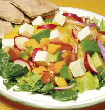  ?? LINDA GASSENHEIM­ER TNS ?? Mango combines with feta cheese and vegetables for a colorful salad supper.