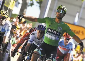  ?? Jeff Pachoud / AFP / Getty Images ?? Peter Sagan, wearing the best sprinter’s green jersey, speeds past Wout van Aert (left) at the finish of Stage 5 of the Tour de France.