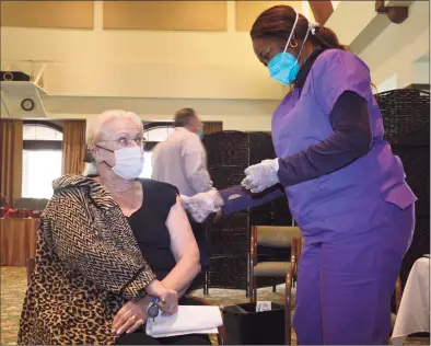  ?? H John Voorhees III / Hearst Connecticu­t Media ?? Gerd Hammarskjo­ld, a resident of Meadow Ridge senior living, waits to receive her COVID-19 vaccinatio­n on Friday from Kerrine McCallum RN on Friday in Redding.