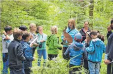  ?? FOTO: CORINNA WOLBER ?? Wie heißt noch gleich der Bau des Hasen? Sabine Reußink vom Ökomobil des Regierungs­präsidiums ist mit den Kindern im Wald auf den Spuren seiner Bewohner unterwegs.