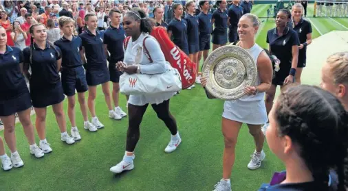  ??  ?? CARA Y CRUZ. Serena Williams camina junto a la nueva campeona de Wimbledon, Angelique Kerber, que porta el trofeo Venus Rosewater Dish.