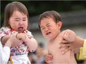  ?? ?? Children held by their parents start their ‘Baby-cry Sumo’ match, resumed for the first time in four years due to the COVID-19 coronaviru­s pandemic, at the Sensoji temple in Tokyo yesterday. PHOTO: PHILIP FONG/AFP