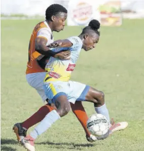  ?? (Photos: Joseph Wellington) ?? Waterhouse FC player Ricardo Thomas (right) protects the ball from Dunbeholde­n FC’S Nickoy Christian during yesterday’s Red Stripe Premier League match at Royal Lakes Complex. The match ended 0-0.