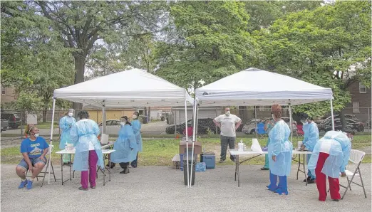  ?? ANTHONY VAZQUEZ/SUN-TIMES ?? Medical personnel clean and prep for tests at a mobile COVID-19 testing station at Edward Coles School in South Chicago on July 8.
