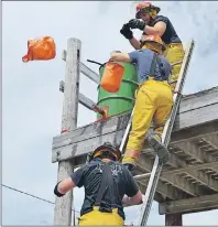  ??  ?? Scotchtown volunteer firefighte­rs compete in the bucket brigade drill during the firefighte­rs competitio­n at the New Waterford fire department Saturday.