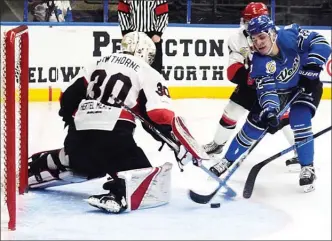  ?? DAVID CROMPTON/Penticton Herald ?? Vees forward David Silye tries to deke around Alberni Valley goaltender John Hawthorne as he is harassed from behind during Penticton’s 2-0 win Saturday at the SOEC.