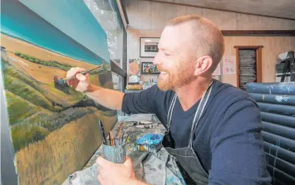  ?? Photo / Warren Buckland ?? Hastings artist Josh Lancaster working on a landscape painting that looks out over Waima¯ rama beach.