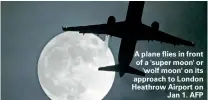  ?? ?? A plane flies in front of a 'super moon' or 'wolf moon' on its approach to London Heathrow Airport on Jan 1. AFP