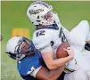  ?? [PHOTO BY BRYAN TERRY, THE OKLAHOMAN] ?? Millwood’s Perry Lewis, bottom, brings down Heritage Hall’s Will Dunn during a high school football game on Thursday night in Oklahoma City.