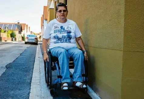  ?? Fotos: Peter Fastl ?? Carmen Sturm kommt mit ihrem Rollstuhl nur mit großer Mühe auf dem Gehweg in der Kreitmayrs­traße voran.