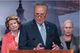  ?? The Associated Press ?? Sen. Debbie Stabenow, D-Mich., left, and Sen. Kirsten Gillibrand, D-N.Y., right, listen as Senate Majority Leader Chuck Schumer, of N.Y., speaks Thursday during a news conference about next week’s vote to codify Roe v. Wade on Capitol Hill in Washington.