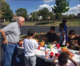  ?? KEVIN MARTIN — THE MORNING JOURNAL ?? Brian Frederick, CEO of the Community Foundation of Lorain County helps some youngsters paint pumpkins at the ONE Lorain County block party celebratio­n on Oct. 7 at the Elyria High School student parking lot on West Avenue.