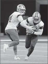  ?? AP/LM OTERO ?? (left) hands off to teammate and running back Ezekiel Elliott during practice Thursday in Frisco, Texas.