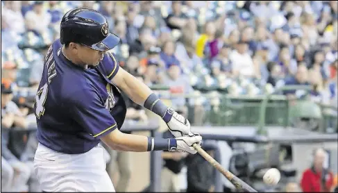  ??  ?? The Brewers’ Hernan Perez hits a sacrifice fly during the first inning against the San Francisco Giants on Monday in Milwaukee.