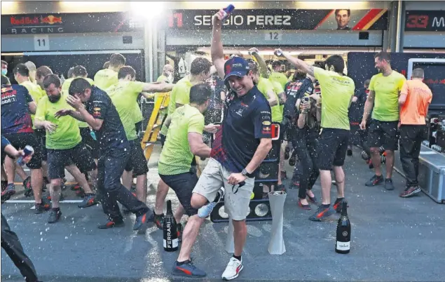  ??  ?? Sergio Pérez, en primer plano, celebra junto al resto del equipo Red Bull su victoria en el GP de Azerbaiyán, celebrado el pasado domingo en el circuito de Bakú.