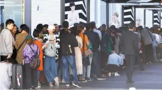  ?? Yonhap ?? Foreign tourists wait for the opening of a duty-free shop in Seoul, Wednesday.