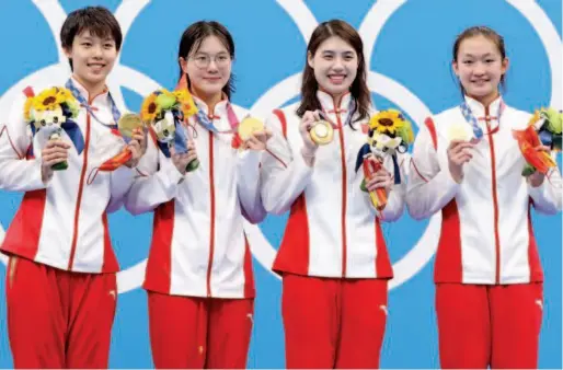  ?? Reuters ?? The Chinese team pose with gold medals on the podium after winning the women’s 4 × 200m Freestyle Relay on Thursday.