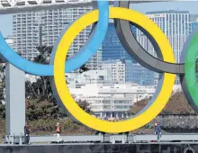  ?? REUTERS ?? Workers reinstall giant Olympic rings at the waterfront area at Odaiba Marine Park in Tokyo on Tuesday, after they were temporaril­y taken down in August.
