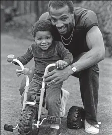  ??  ?? On his bike: Regis plays with son Robert in 1982